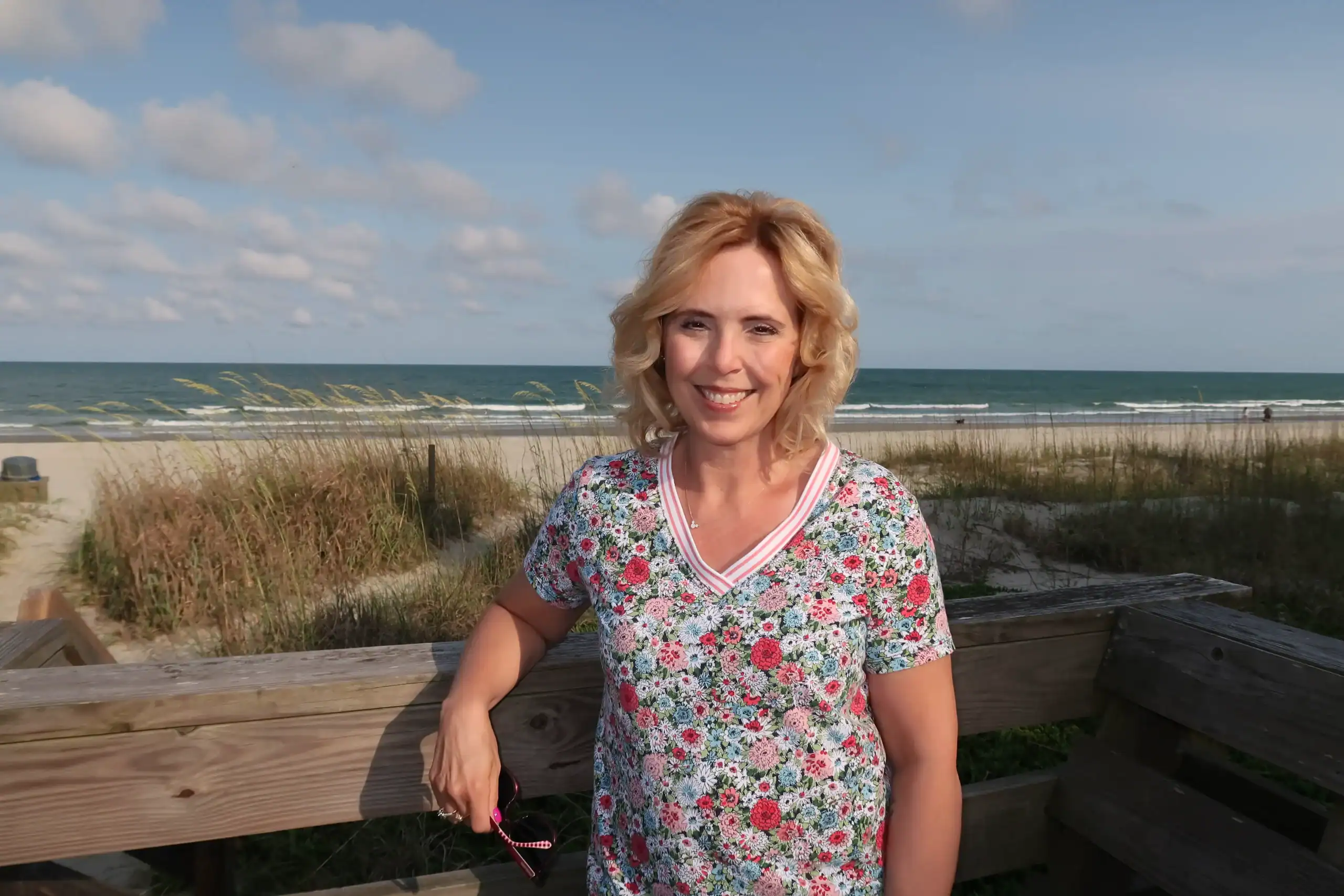 Woman smiling at the beach, representing work at 407&Beyond.