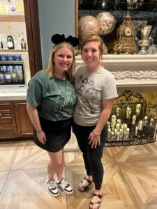 Two women smiling at 407&Beyond, one wearing Mickey Mouse ears.