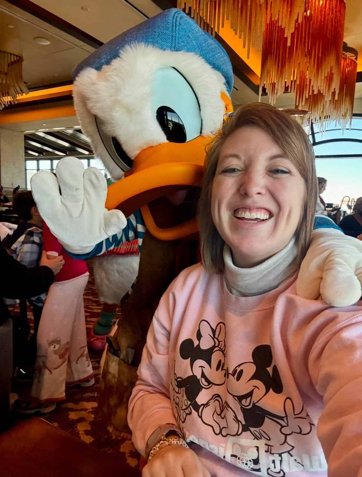 Libby Garcia smiling with Donald Duck mascot at 407&Beyond event.